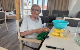 Alltagskompetenzen stärken Seniorin schneidet lächelnd Kartoffeln