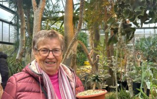 Botanischer Garten Marburg Seniorin hält einen kleinen Kaktus im Topf