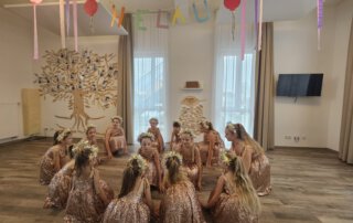 Fasching 2025 – Tanz, Musik und gute Laune Tanzgruppe in glitzernden Kostümen sitzt beim Auftritt auf dem Boden