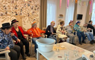 Fasching 2025 – Tanz, Musik und gute Laune Verkleidete Gäste mit Hüten sitzen in fröhlicher Runde