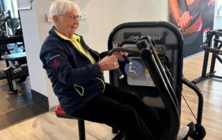 Regelmäßige Besuche im Fitnessstudio Seniorin trainiert an einem Rudergerät