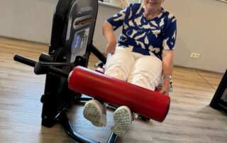 Regelmäßige Besuche im Fitnessstudio Seniorin an der Beinstreckmaschine