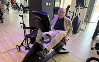 Regelmäßige Besuche im Fitnessstudio Senior trainiert auf einem Liegeergometer