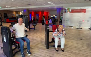 Regelmäßige Besuche im Fitnessstudio Senior und Seniorin trainieren nebeneinander