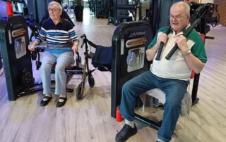 Regelmäßige Besuche im Fitnessstudio Seniorin und Senior trainieren an Armgeräten