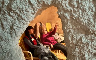 Blick durch eine Öffnung in der Salzwand auf Gäste, die in Liegestühlen entspannen