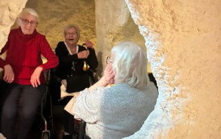 Drei Seniorinnen sitzen in der Salzgrotte und unterhalten sich