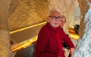 Gast im roten Pullover sitzt in einer Nische der Salzgrotte