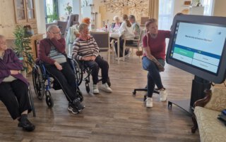 Digitalisierung zum Anfassen-Der Care Table ist da! Gäste im Sitzkreis spielen ein Quiz auf dem Care Table