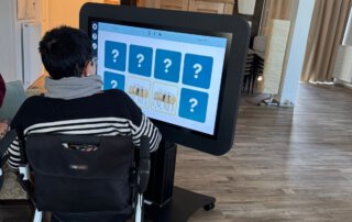 Digitalisierung zum Anfassen-Der Care Table ist da! Gast im Rollstuhl spielt ein Memory auf dem Bildschirm