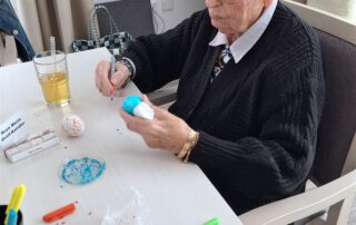 Ostereier färben mit der Kita Regenbogen Senior bemalt ein Osterei in Türkis