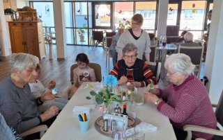 Ostereier färben mit der Kita Regenbogen Gäste und Kinder sitzen beim Eierfärben zusammen