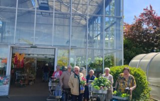 Gäste mit Pflanzen vor dem Eingang des Garten-Centers Meckelburg