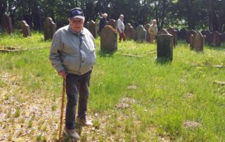 Senior mit Gehstock steht auf dem Judenfriedhof Neustadt