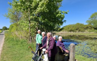Gäste mit Rollator stehen am Ufer des Winshäuser Teichs