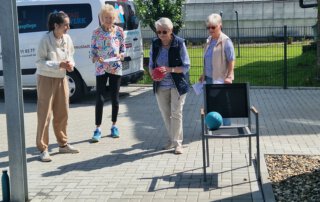 Seniorenolympiade mit Herz und jeder Menge Bewegung Seniorinnen beim Ballwurf an einer Station der Olympiade