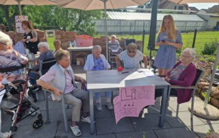Sommer, Sonne, Gemeinschaft Gäste und Angehörige sitzen beim Sommerfest an Tischen