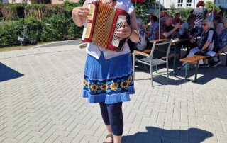 Sommer, Sonne, Gemeinschaft Akkordeonspielerin unterhält die Gäste beim Sommerfest