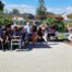 Gäste und Angehörige sitzen beim Sommerfest unter Pavillons auf dem Hof