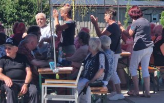 Sommer, Sonne, Gemeinschaft Gäste singen und klatschen beim Sommerfest
