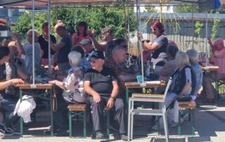 Sommer, Sonne, Gemeinschaft Volle Biertischreihen beim Sommerfest