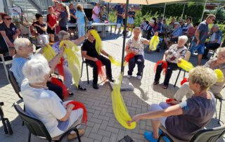 Sommer, Sonne, Gemeinschaft Gäste schwingen bei ihrer Darbietung gelbe Tücher
