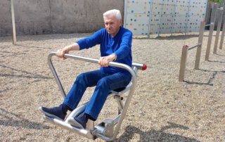 Senior trainiert an einem Outdoor-Fitnessgerät im Freizeitsportbereich