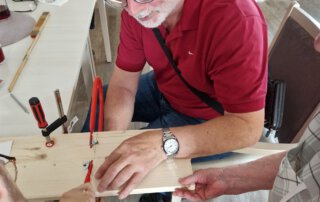 Senior werkelt an einem Holzbrett