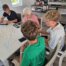 Schüler spielen mit einer Seniorin ein Legespiel