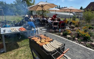 Zwei sommerliche Grillwochen mit fröhlicher Stimmung Würstchen auf dem Grill im Garten