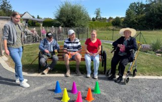 Zwei sommerliche Grillwochen mit fröhlicher Stimmung Gäste sitzen auf einer Bank und spielen ein Wurfspiel mit Hütchen