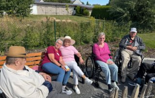 Zwei sommerliche Grillwochen mit fröhlicher Stimmung Gäste unterhalten sich auf den Bänken im Garten