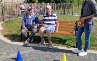 Zwei sommerliche Grillwochen mit fröhlicher Stimmung Zwei Senioren auf der Bank beim Spiel mit bunten Hütchen