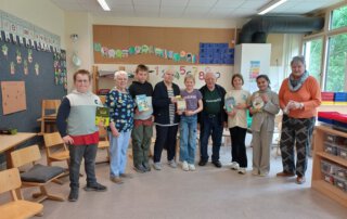 Meet and Read Schüler und Senioren stehen gemeinsam im Klassenraum