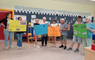 Meet and Read Kinder und Senioren halten bunte Plakate im Klassenzimmer
