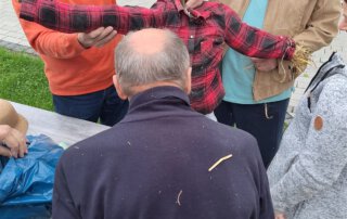 Senioren halten das Gestell der Vogelscheuche