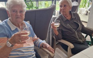 Wenn das Wasser im Rhein goldener Wein wär, … Zwei Seniorinnen stoßen mit alkoholfreiem Wein an