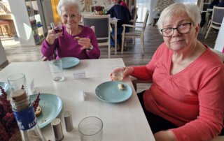 Wenn das Wasser im Rhein goldener Wein wär, … Zwei Seniorinnen trinken Wein am Tisch